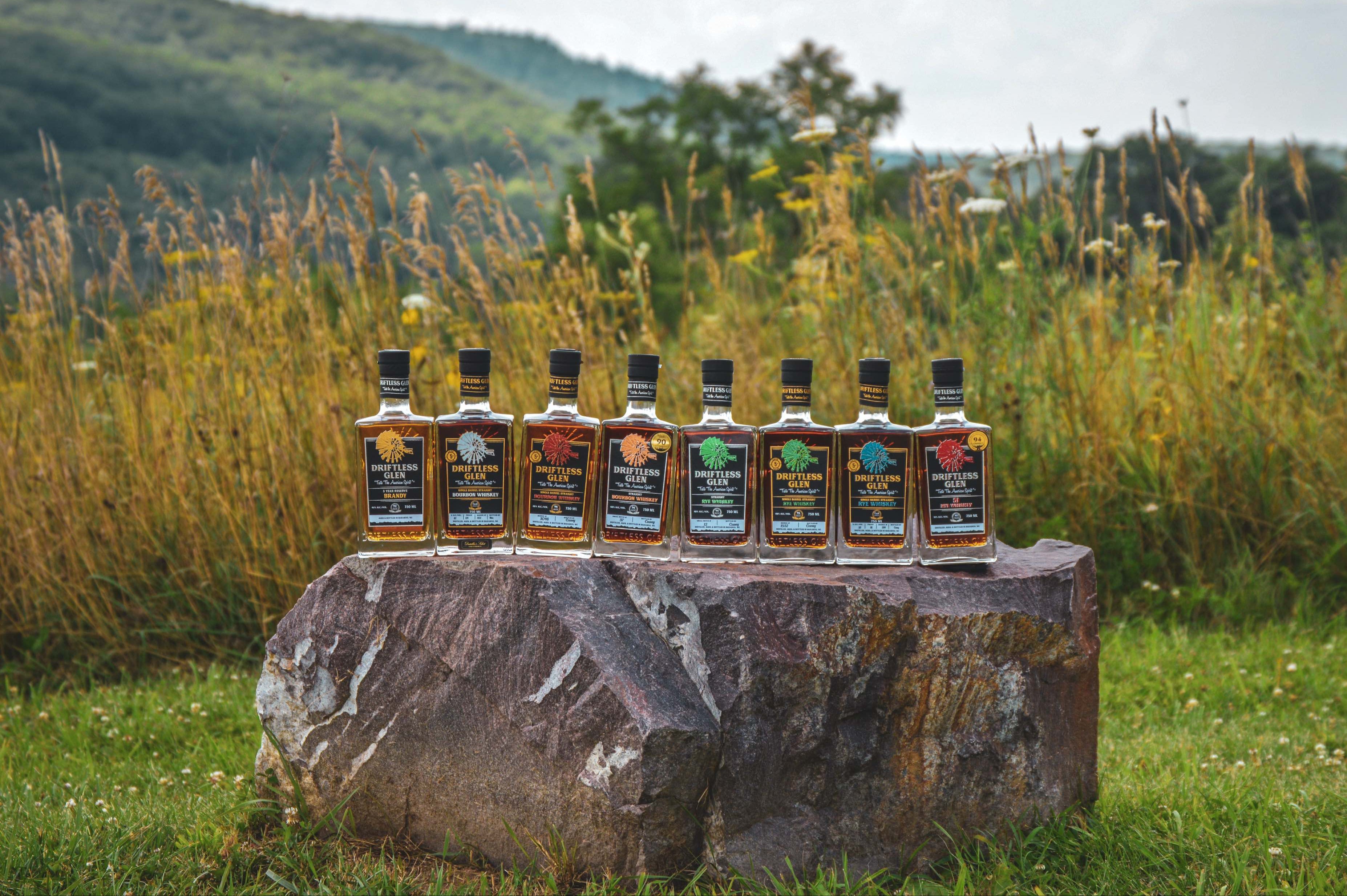 8 bottles of Driftless Glen in a field